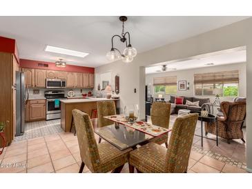 Open floorplan view of kitchen, dining area, and living room with lots of natural light at 8229 E Farmdale Dr, Mesa, AZ 85208