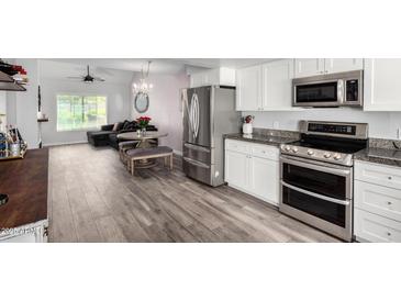 Bright kitchen features stainless appliances, granite countertops, wood-look tile flooring, and dining area at 860 N Mcqueen Rd # 1213, Chandler, AZ 85225
