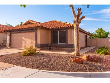 Beige home with a 2-car garage, driveway, and desert landscaping at 910 W Redondo Dr, Gilbert, AZ 85233