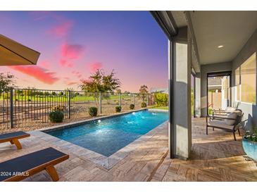 Inviting outdoor pool area with a fountain, lounge chairs, and a covered patio overlooking a manicured golf course at 11656 N San Clemente St, Surprise, AZ 85388