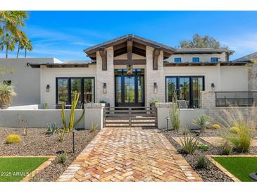 Inviting front elevation with brick pathway, private courtyard, desert landscaping and beamed entry at 12633 N 81St St, Scottsdale, AZ 85260