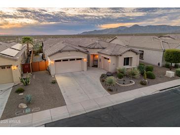 Charming single-Gathering home with a three car garage and beautiful desert landscaping at dusk at 20289 N 259Th Ave, Buckeye, AZ 85396