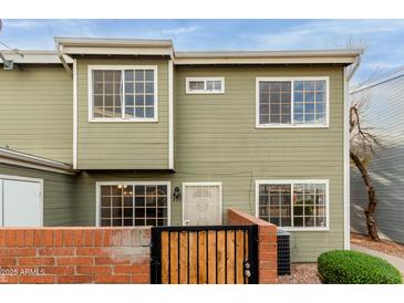 Inviting two-story home featuring a gated entrance, well-maintained landscaping, and a welcoming facade at 2301 E University Dr # 393, Mesa, AZ 85213