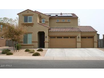 Inviting two-story home featuring a three-car garage, desert landscaping, and solar panels at 2917 S 121St Ln, Tolleson, AZ 85353