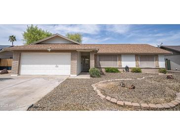 Charming single-story home featuring a well-maintained front yard with desert landscaping, brick accents, and a two-car garage at 402 W Mohawk Ln, Phoenix, AZ 85027