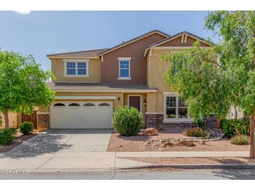 Inviting two-story home featuring a three-car garage, landscaped yard, and a mix of textures and colors on the facade at 4125 W Lydia Ln, Phoenix, AZ 85041