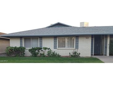 Charming single-story home featuring a brick exterior, well-manicured lawn, and decorative window accents at 4549 W Seldon Ln, Glendale, AZ 85302