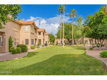 Beautiful grassy community area with mature trees and desert landscaping under sunny blue skies at 5450 E Mclellan Rd # 150, Mesa, AZ 85205
