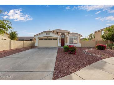 Charming single-story home featuring a two-car garage, red rock landscaping, and a cozy front porch at 7215 N 76Th Ave, Glendale, AZ 85303