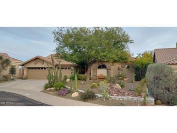 Charming single-story home featuring desert landscaping, barrel cactuses, and a cozy bench under a tree at 7517 E Mariposa Grande Dr, Scottsdale, AZ 85255