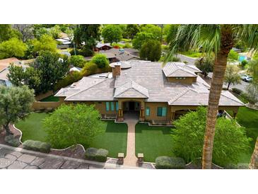 Expansive property boasting manicured lawns, mature trees, and a well-maintained house with distinctive architectural elements at 823 W Palo Verde Dr, Phoenix, AZ 85013
