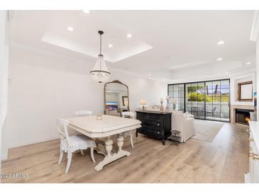Elegant living room featuring light wood floors, a chandelier, and a cozy fireplace at 902 W Glendale Ave # 215, Phoenix, AZ 85021