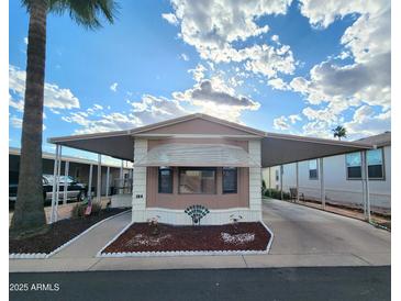 Charming manufactured home featuring covered parking and a well-maintained front yard with decorative landscaping at 9333 E University Dr # 184, Mesa, AZ 85207