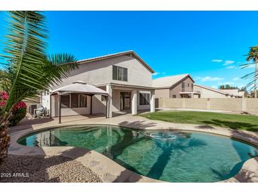 Backyard view of a refreshing private pool, covered patio and a glimpse of desert landscaping at 11317 W Cottonwood Ln, Avondale, AZ 85392