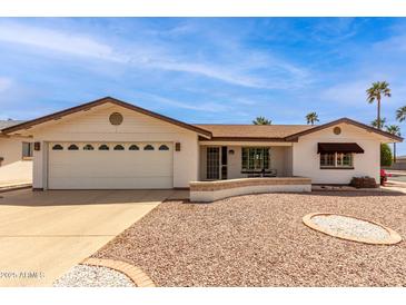 Charming single-story home with a two-car garage and well-maintained desert landscaping at 8011 E Milagro Ave, Mesa, AZ 85209