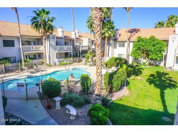 Community pool and spa surrounded by lush landscaping and palm trees add resort-style living at 930 N Mesa Dr # 2027, Mesa, AZ 85201