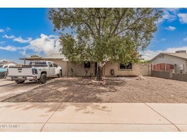 Charming single-story home featuring a large tree and gravel landscaping for low maintenance at 10723 N 80Th Ln, Peoria, AZ 85345