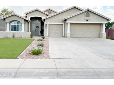 Charming home featuring a well-manicured lawn, a two-car garage, and a welcoming entrance at 1892 S Arroyo Ln, Gilbert, AZ 85295