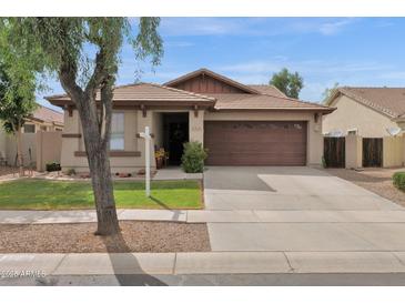 Tan single-story home with a brown roof, a two-car garage, and grassy front lawn at 4364 S Tatum Ln, Gilbert, AZ 85297