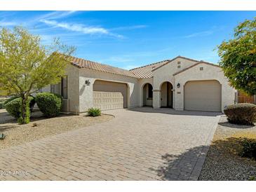 Charming single-story home featuring a tile roof, paver driveway, and a well-manicured front yard at 4417 N 156Th Dr, Goodyear, AZ 85395