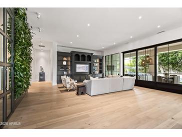Bright, open living room with a living plant wall, large entertainment center, and sliding doors to the patio at 4901 E Lafayette Blvd, Phoenix, AZ 85018