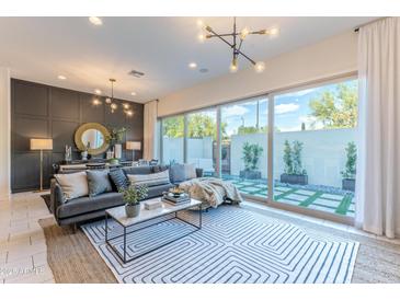 Bright living room with large sliding glass doors to outdoor patio, stylish furnishings, and unique lighting at 7330 E Vista Bonita Dr, Scottsdale, AZ 85255