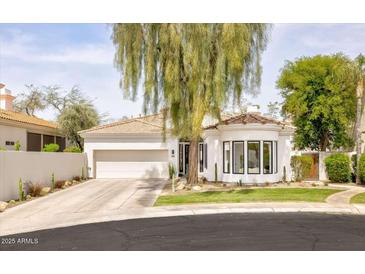 Charming single-story home featuring a tiled roof, desert landscaping, and a spacious two-car garage at 7670 E Sierra Vista Dr, Scottsdale, AZ 85250