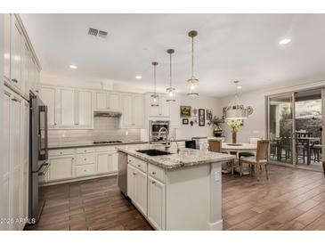 Bright kitchen features a large island, stainless steel appliances, and adjacent dining area at 10260 E White Feather Ln # 1022, Scottsdale, AZ 85262