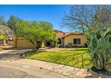 Charming single-story home featuring a well-manicured lawn, mature trees, and desert landscaping at 10837 W Cottonwood Ln, Avondale, AZ 85392
