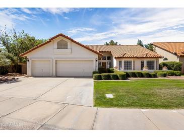 Charming single-story home featuring a three-car garage, a well-maintained lawn, and a classic Southwestern design at 1110 N Gull Haven Ct, Gilbert, AZ 85234