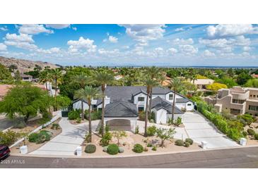 A stunning exterior elevation showcases a grand home with meticulous landscaping and a porte cochere at 11827 S Montezuma Ct, Phoenix, AZ 85044