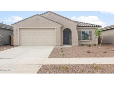 Single-story home featuring a neutral color palette, tiled roof, and attached two-car garage at 17764 W Getty Dr, Goodyear, AZ 85338