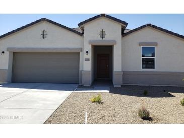Charming single-story home featuring a low-maintenance desert-style front yard and a two car garage at 18823 E Bruno Dr, Gold Canyon, AZ 85118
