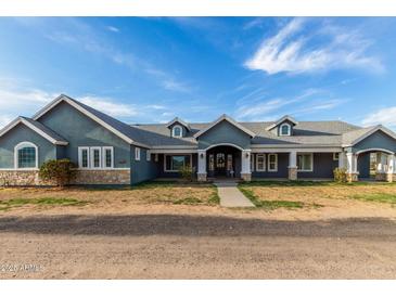 Charming single-story home featuring a well-manicured lawn, inviting entrance, and classic architectural details at 18934 E Happy Rd, Queen Creek, AZ 85142
