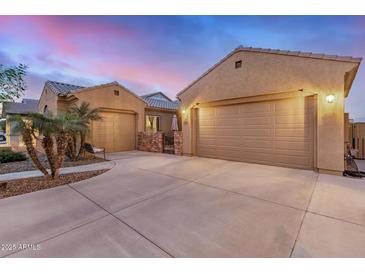 Stunning home exterior featuring attached garages, desert landscaping, and a stone courtyard entrance at 1916 E Dubois Ave, Gilbert, AZ 85298
