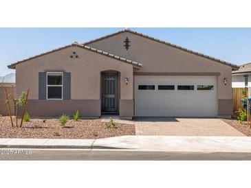 A charming single-story home with a two-car garage, neutral stucco exterior, and low-maintenance desert landscaping at 24493 W Grenadine Rd, Buckeye, AZ 85326