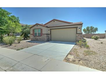 Charming single-story home featuring a two-car garage and low maintenance desert landscaping with stone accents at 25755 W Hazel Dr, Buckeye, AZ 85326