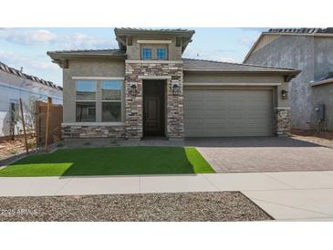 Charming single-story home featuring stone accents, a two-car garage and well-manicured front lawn at 26079 S 228Th St, Queen Creek, AZ 85142