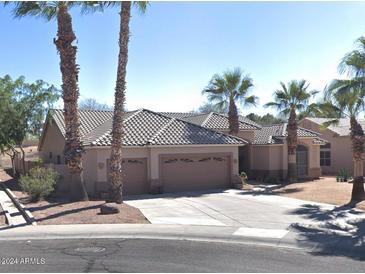 Beautiful single-story home featuring well-manicured landscaping, a three-car garage, and desert accents like palm trees at 665 W Beechnut Dr, Chandler, AZ 85248