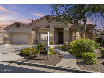 Charming single-story home with desert landscaping, covered entryway, and attached two-car garage at 9733 W Hedge Hog Pl, Peoria, AZ 85383
