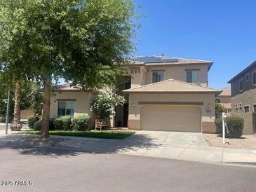 Two-story home with desert landscaping, large shade tree and two car garage at 17394 W Pima St, Goodyear, AZ 85338