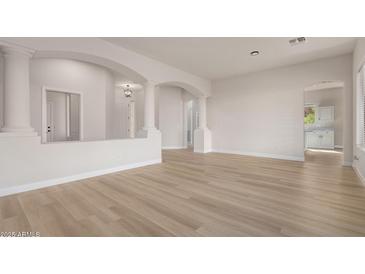 Open-concept living room featuring decorative columns and light wood flooring at 1112 E Winged Foot Dr, Chandler, AZ 85249
