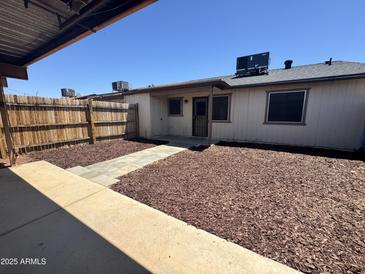 A nice backyard with a wood fence, wood chips, and a patio walkway at 5120 W Willow Ave, Glendale, AZ 85304