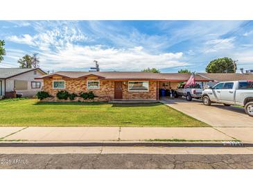 Charming brick home featuring a lush lawn, long driveway, and a covered parking area for your vehicles at 1143 E 7Th St, Mesa, AZ 85203