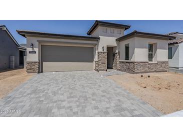 Beautiful, modern home featuring a two-car garage and stone accents at 11996 N Luckenbach St, Surprise, AZ 85388