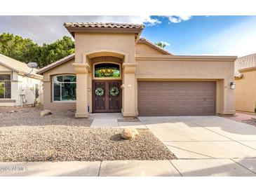 Charming home with tile roof, desert landscaping, and a decorative double door entrance at 1447 E Nighthawk Way, Phoenix, AZ 85048