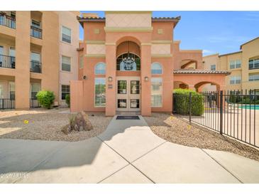 Inviting multi-story building featuring stucco walls, arched entryway, and manicured desert landscaping at 14575 W Mountain View Blvd # 11315, Surprise, AZ 85374