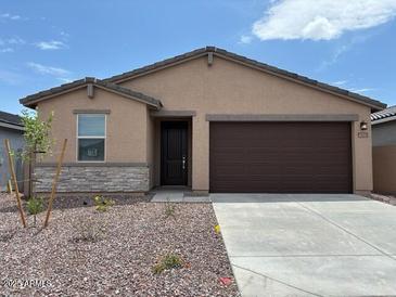 Charming single-story home features a two-car garage and well-maintained landscaping at 17433 W Eva St, Waddell, AZ 85355