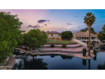 Wonderful lakefront property featuring a tiered backyard and mature trees at sunset at 175 N Brookside St, Chandler, AZ 85225