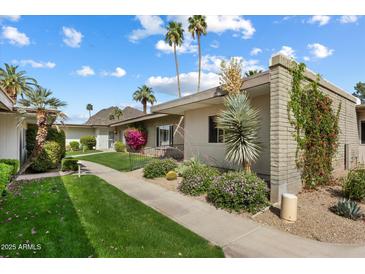 Inviting home exterior with desert landscaping and palm trees, with mountain views in the background at 4800 N 68Th St # 270, Scottsdale, AZ 85251